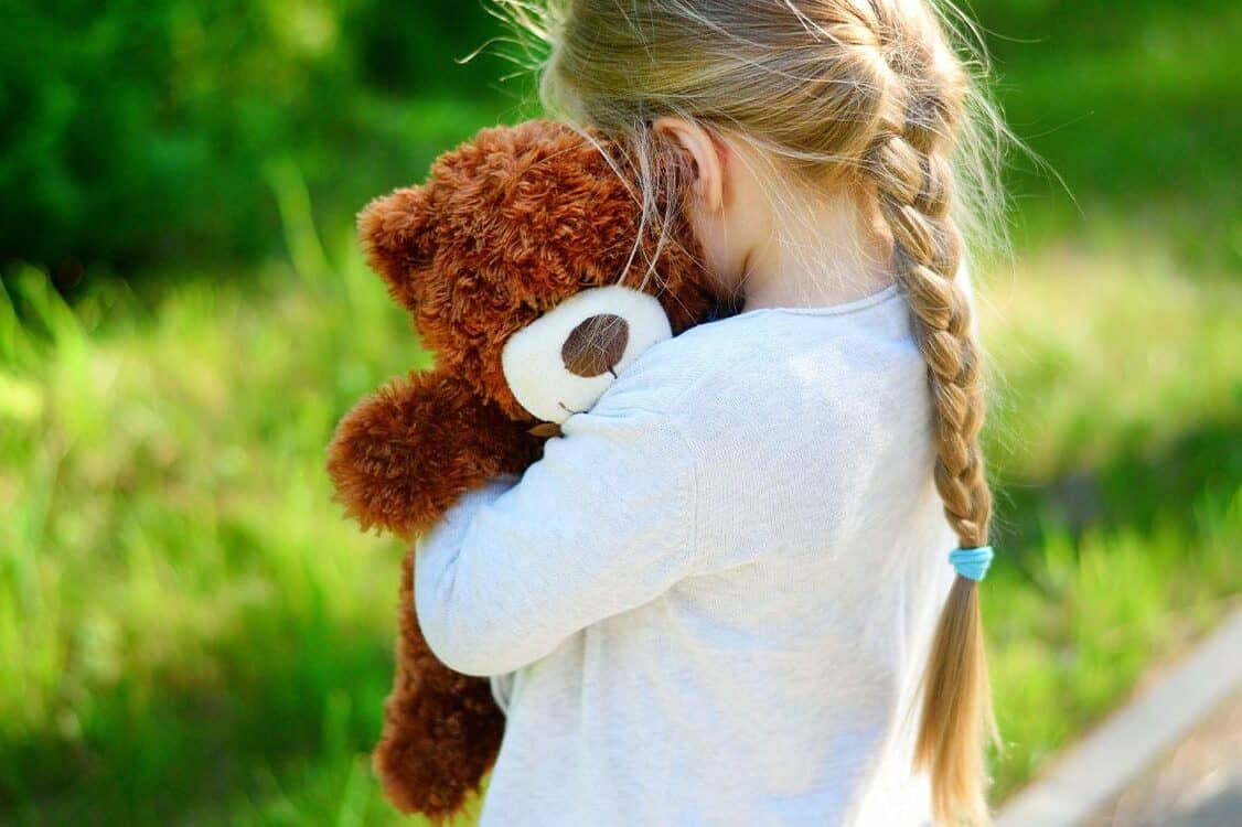 Child holding teddy bear - Report daycare abuse