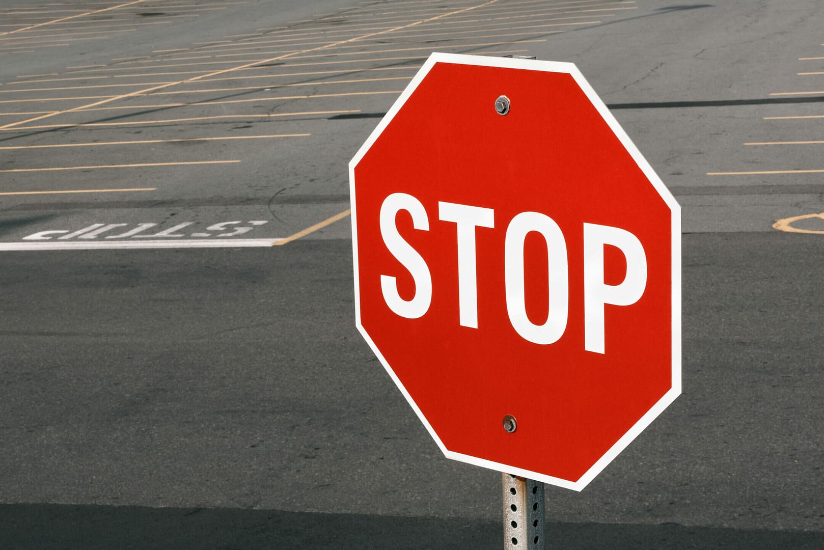 Stop sign in front of parking lot.
