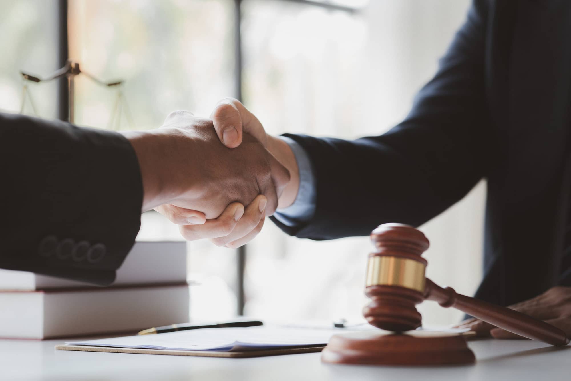 Lawyers shake hands with clients who come to testify in the case of embezzlement from business partners who jointly invest in the business. The concept of hiring a lawyer for legal proceedings. Uber or Lyft Accident. Personal Injury Lawyer