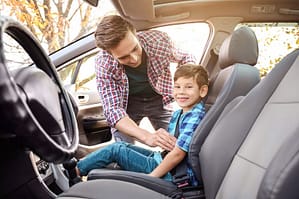 Child sitting in front seat of car - Age kids can ride in the front seat by state