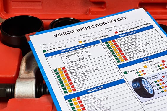 Vehicle vehicle inspection report form against the background of automotive tools. Close up. Texas vehicle inspection laws