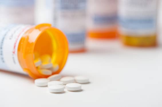 Frasco de medicamentos recetados volcado y las pastillas derramándose - Abogados de lesiones por drogas peligrosas