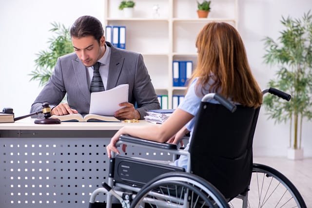 Young injured woman in a wheelchair consulting with her slip & fall attorney