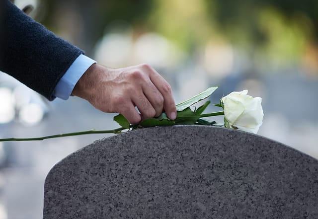 Man placing a flower on a grave - Corpus Christi Wrongful Death Lawyers