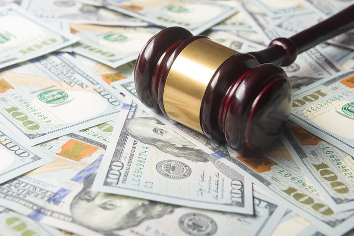 Gavel sitting on top of $100 bills - What are the Pros and Cons of Being a Personal Injury Lawyer?