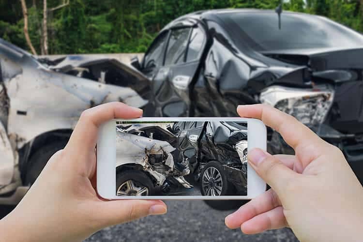 Woman photographing car accident before looking for the best lawyer in Houston for car accidents