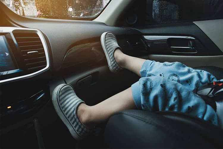 Kid's feet on a car dashboard