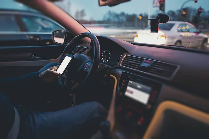 Foto de un hombre enviando mensajes de texto y conduciendo. Intersecciones más peligrosas en San Antonio, TX