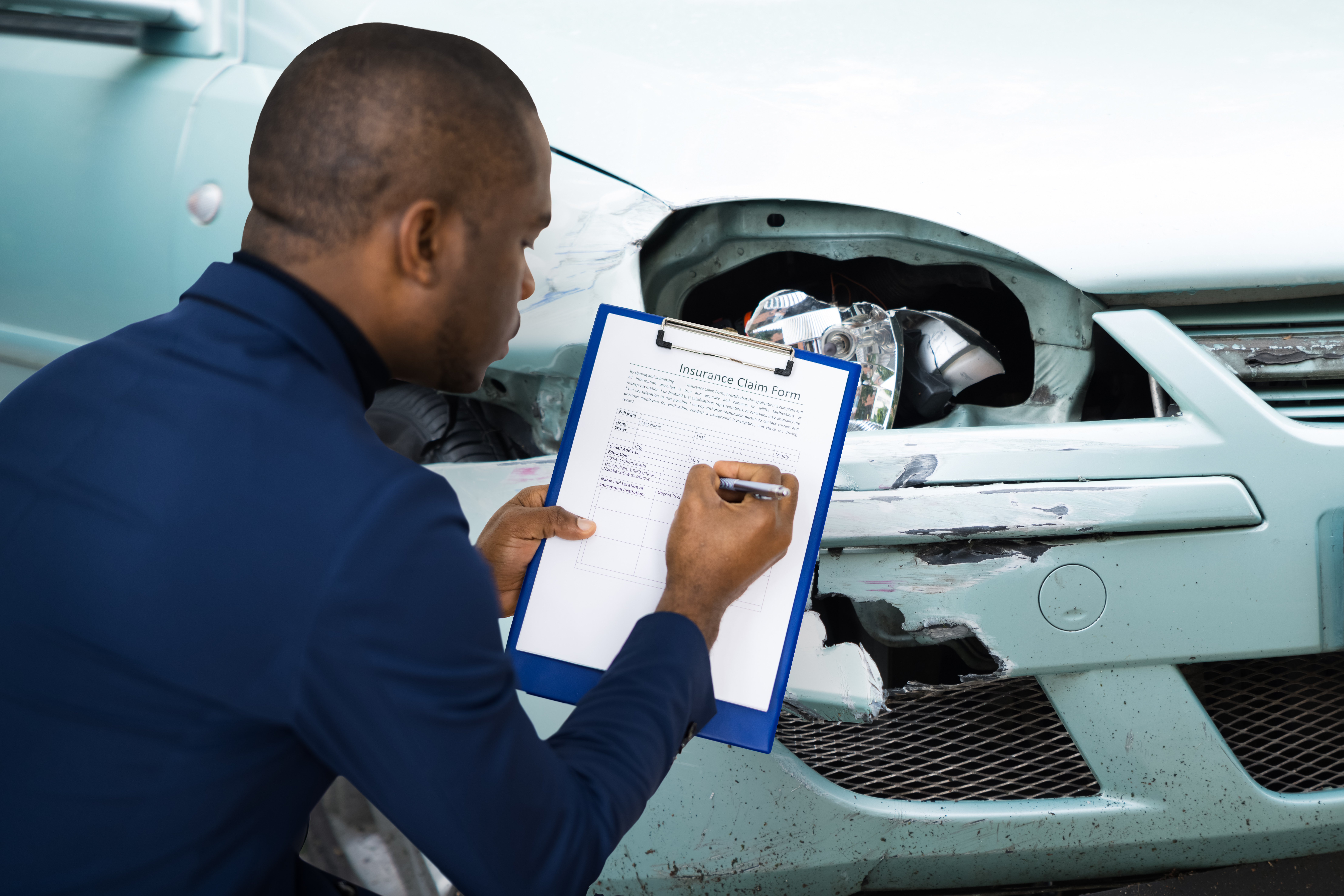 African American Car Insurance Adjuster Inspecting Accident Claim