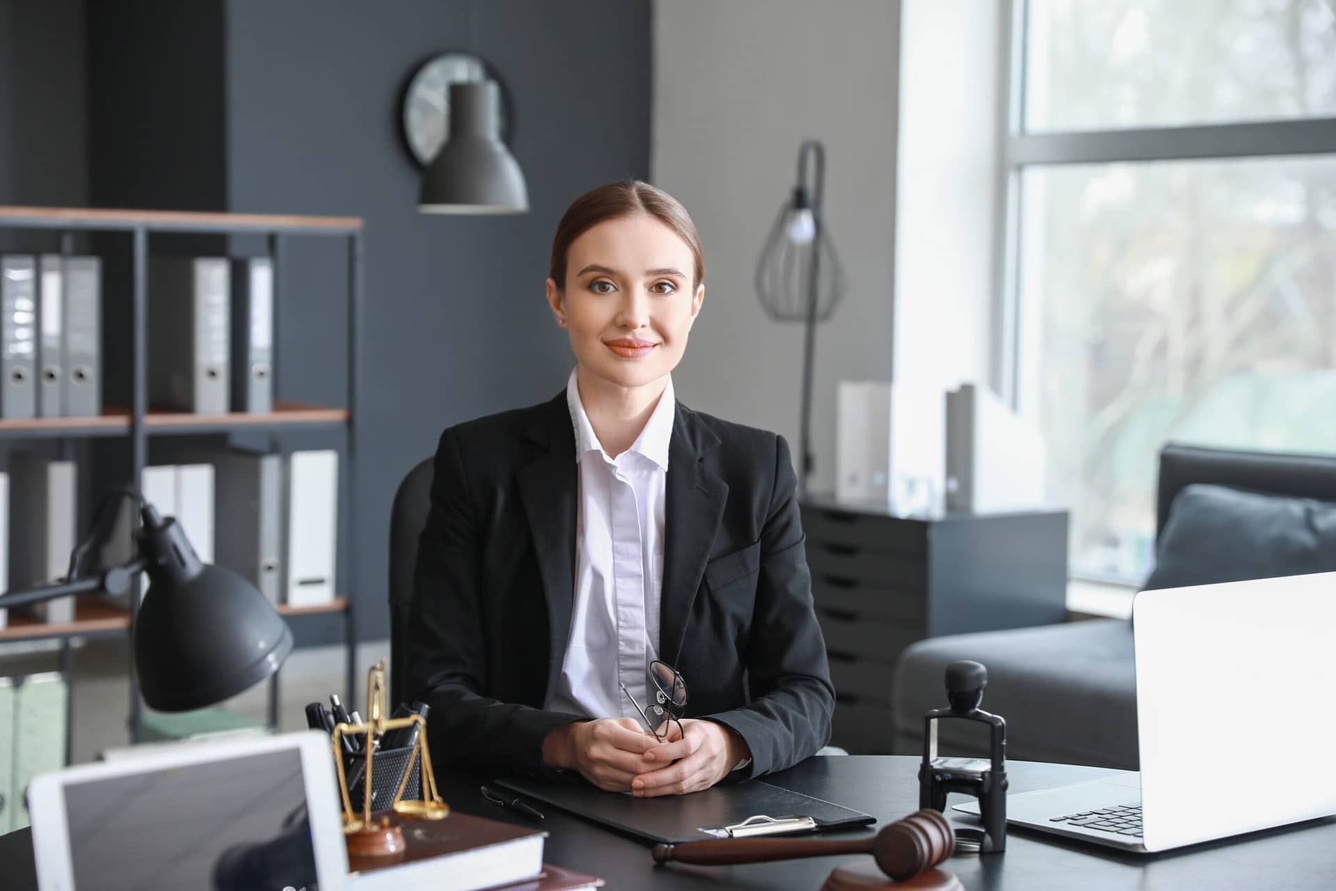 Female lawyer sitting at workplace in office. Compensation